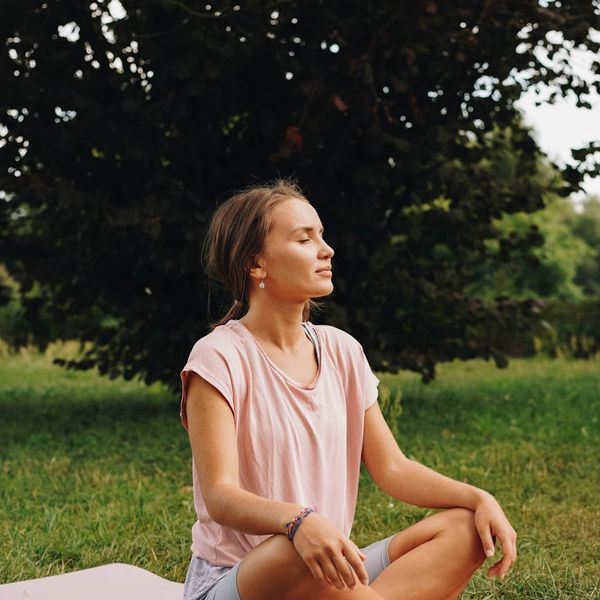 Person sitting calmly by a window, focusing on breathing exercises.