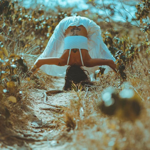 Smiling person stretching outdoors at sunrise, feeling energized and positive.