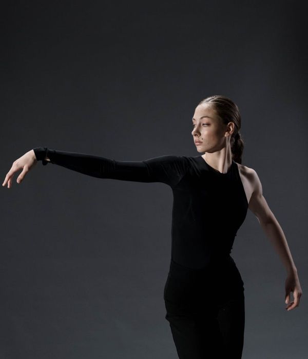 Woman in activewear performing a fluid cardio movement in a modern studio.